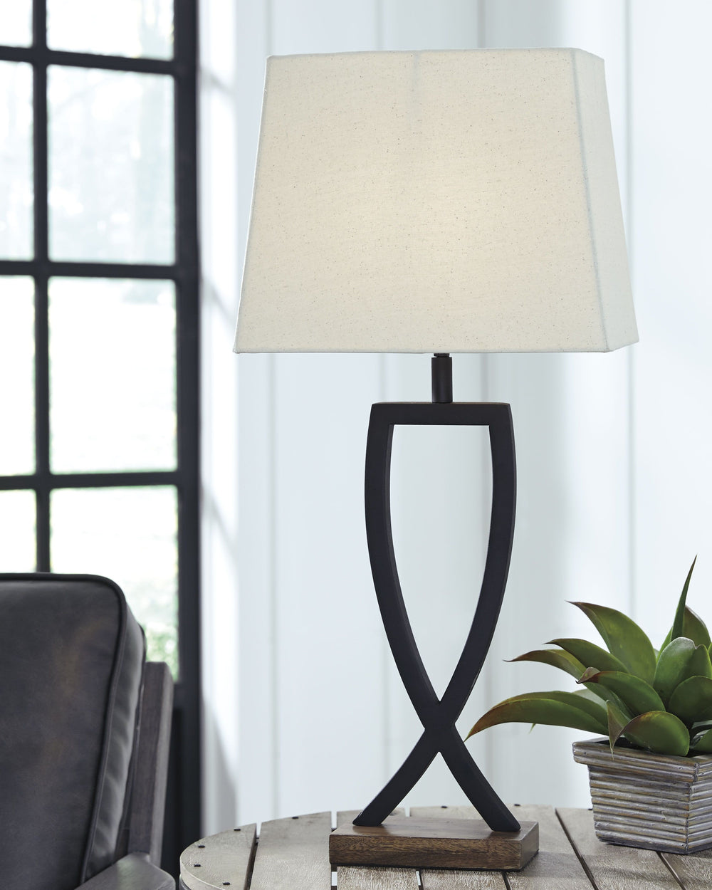 This table lamp is an enticing merge of mixed materials. Textured black finished metal stands poised atop a block of warm brown wood. Open design is right at home among casual decor.<br><br><b>Additional Dimensions</b><br><ul><li>Shade: 0-"</li><li>Cord l
