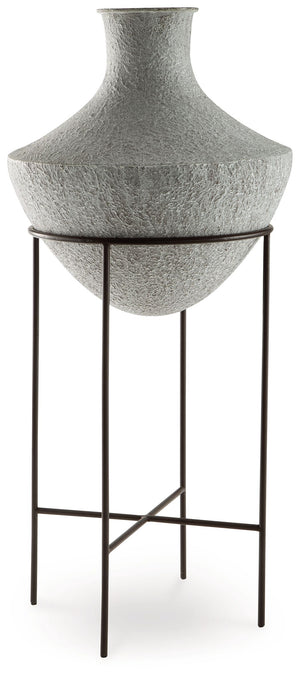 Take an effortlessly inviting approach to floor decor. This vase-'s distressed, textured look in a neutral hue pairs with a variety of casual color palettes. An espresso brown stand adds charming contrast to the look. And this vase enthusiastically welcom