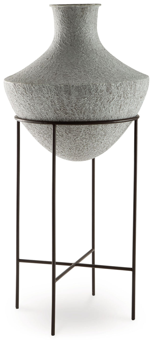 Take an effortlessly inviting approach to floor decor. This vase-'s distressed, textured look in a neutral hue pairs with a variety of casual color palettes. An espresso brown stand adds charming contrast to the look. And this vase enthusiastically welcom