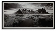 If you have your sights set on a striking landscape, this wall art is a natural wonder. Staggeringly beautiful, the framed black and white print showcases majestic mountains and a meandering stream. This moody and marvelous piece adds an air of dramatic b