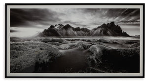 If you have your sights set on a striking landscape, this wall art is a natural wonder. Staggeringly beautiful, the framed black and white print showcases majestic mountains and a meandering stream. This moody and marvelous piece adds an air of dramatic b