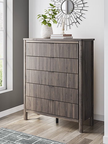 Crafted with both form and function in mind, this chest of drawers brings a dash of retro-cool character to your modern boho aesthetic. Reeded accents add an on-trend touch to its classic silhouette. Warmly welcoming with a rich brown finish, the piece pa