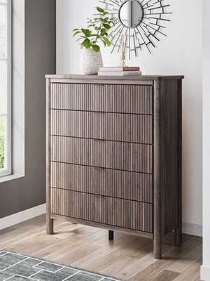 Crafted with both form and function in mind, this chest of drawers brings a dash of retro-cool character to your modern boho aesthetic. Reeded accents add an on-trend touch to its classic silhouette. Warmly welcoming with a rich brown finish, the piece pa