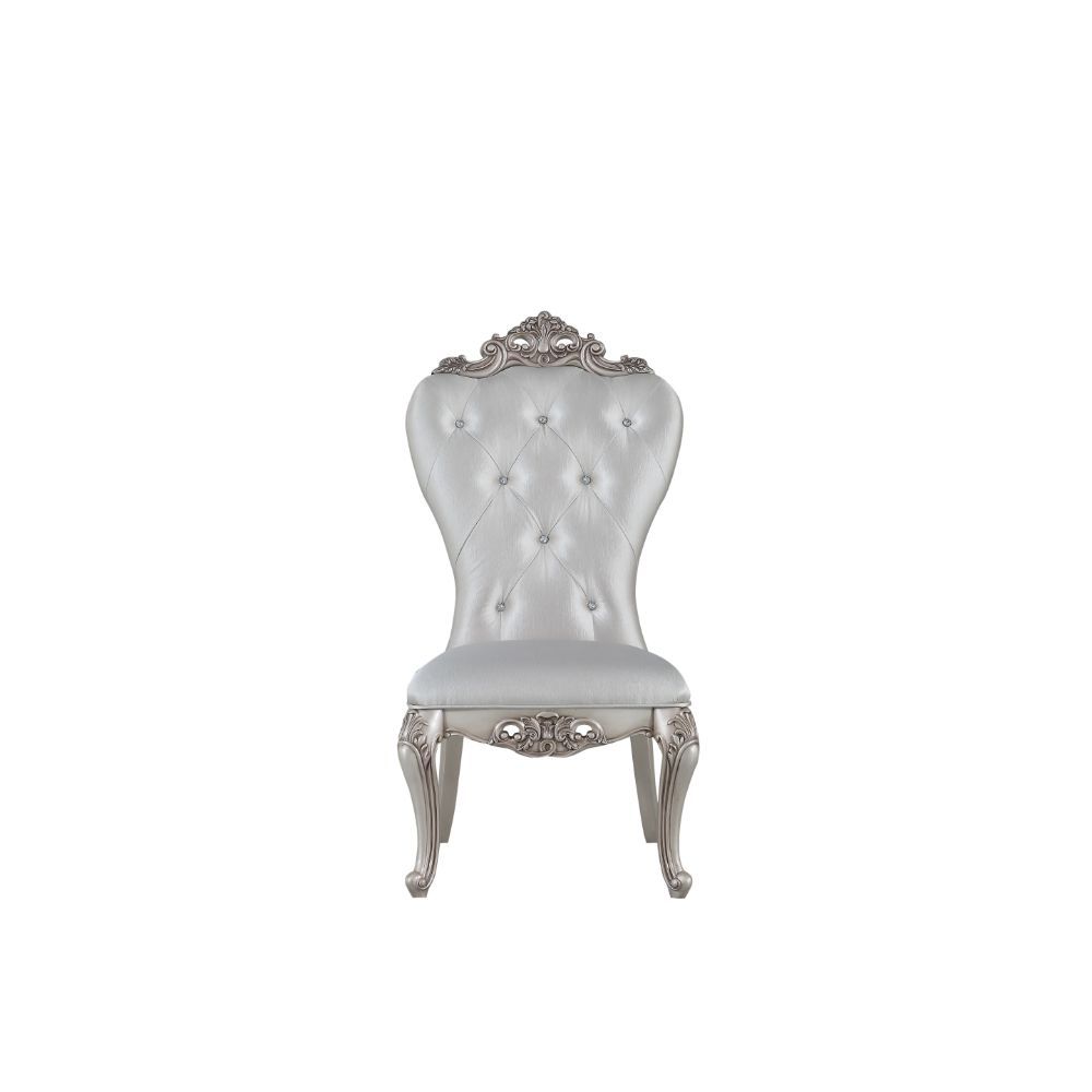 Exclusively designed and filled with romantic spirit, this beautiful chair features Queen Anne legs and carved apron and trim, decorated with raised and scrolled floral motifs in an antique champagne finish. This unique chair is upholstered in a cream fab