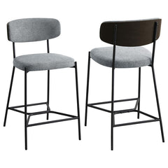 Introduce comfort and style with a set of two contemporary counter stools for your kitchen. Each features a black finish metal frame, offering streamlined character with slim structure and geometric details. Light, neutral upholstery covers foam cushions,