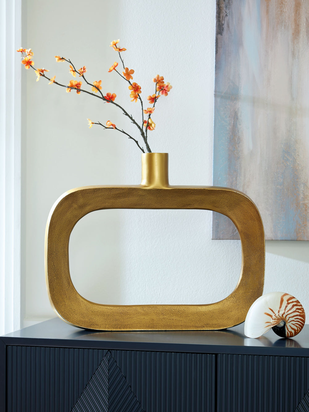 Geometric forms get a glam upgrade in this vase. Decidedly contemporary with its sculptural silhouette, it ushers a confidently curated vibe into your space. The goldtone finish brings an eye-catching metallic flair to your mantel, bookshelf or centerpiec