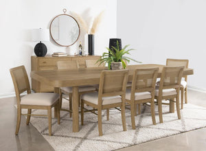 This dining set blends modern craftsmanship with natural textures for a refined yet inviting feel. The dining table features a trestle base with an antique brass-finished metal stretcher bar, adding stability and contrast. Rounded corners soften the recta
