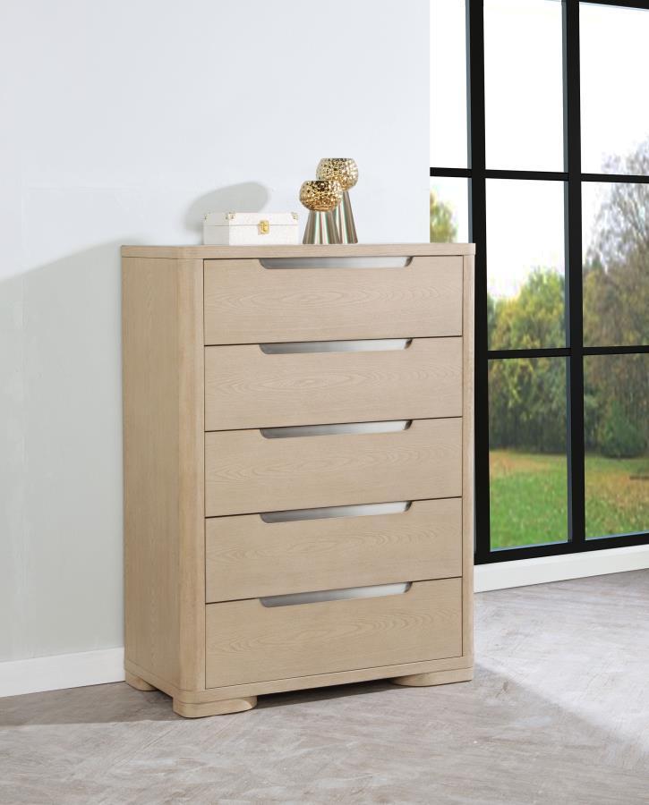 This five-drawer chest offers a balance of style and storage with its light elm finish and brushed nickel fingertip pulls. Rounded corners enhance its sleek design, while extra-large tinted drawers provide ample storage. Built with French dovetail fronts,