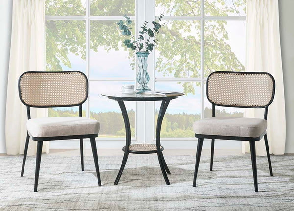 The Frydel is the perfect table set for your home. This three-piece round table set includes a glass tabletop with a rattan lower shelf and black frame, as well as two rattan chairs with a plush seat cushion. The glass and rattan, so it-'s easy to clean. 