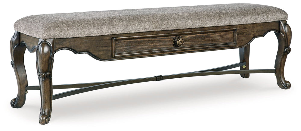 From its ornamental appliques to its large scale, this dining bench makes a bold statement. With ornately shaped legs, a plush cushioned seat and a storage drawer, the opulent bench wows with stunning style. The look is timeless. The feel? Right at home.<