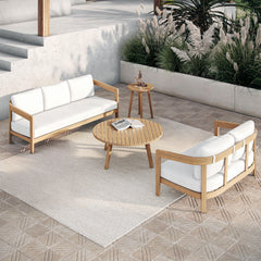 The Wesley 4-Piece Wood Patio Set, featuring a spacious outdoor sofa, a cozy loveseat with plush white cushions, a coffee table, and an end table, effortlessly combines durability, comfort, and modern design for a stylish outdoor retreat. Expertly crafted