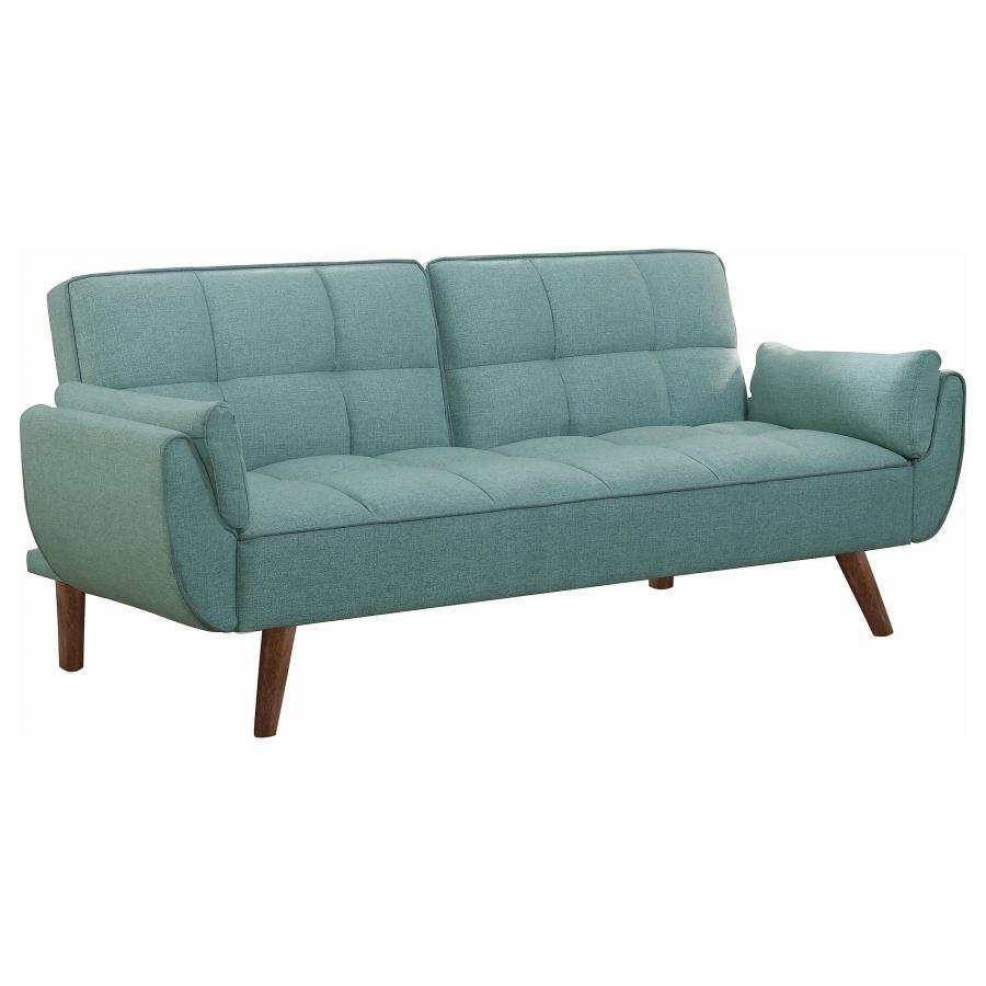 Add a pleasing pop of color to your living room or den. This charming sofa bed is upholstered with a soft, woven fabric in a stunning shade of turquoise blue. A biscuit-tufted seat and back give it a touch of updated glamour. With a soft, fuzzy white acce