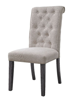 Beige linen upholstery fully covers its wooden frame for a light and airy feel. The side chair boasts a rolled back design with tufted button details, which embodies a timeless look with a classic flair. Wooden legs in a muted gray finish lend a bit of na