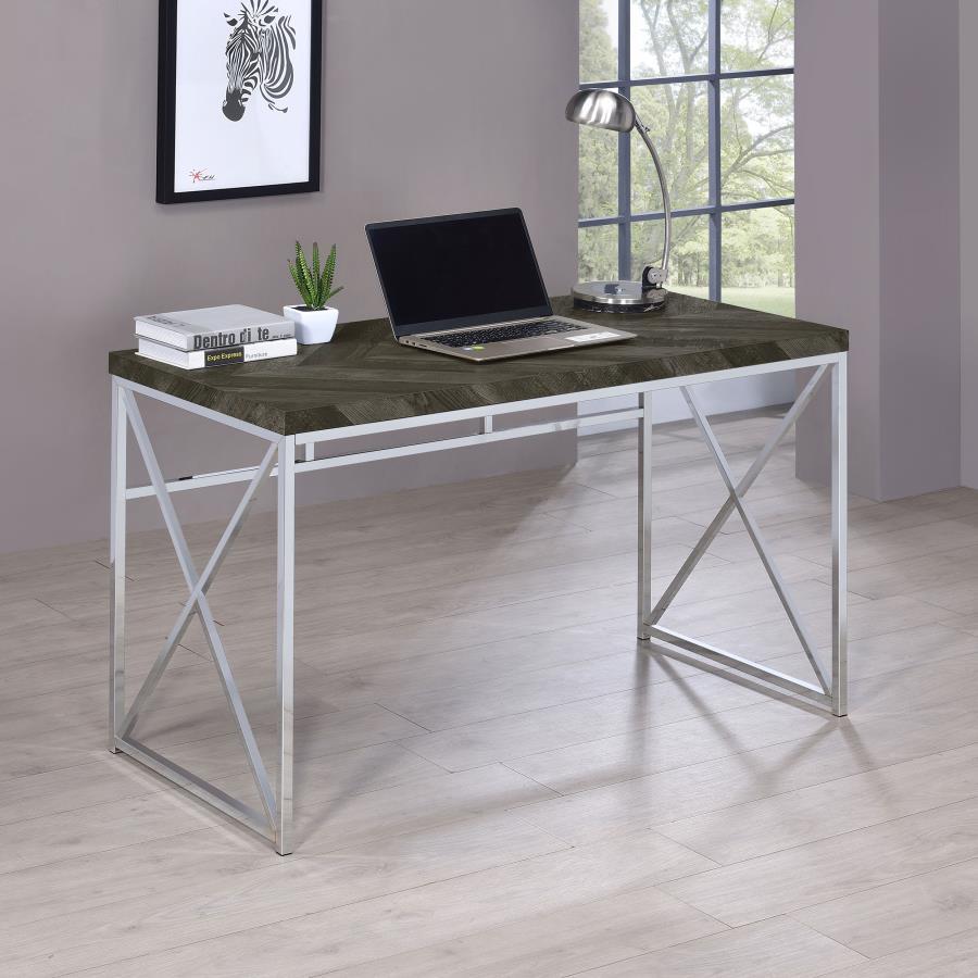 Add modern sophistication to your workspace with this writing desk, featuring a sleek rustic grey herringbone finish that blends contemporary and industrial styles. Its sturdy metal frame, finished in polished chrome, provides a geometric aesthetic with b