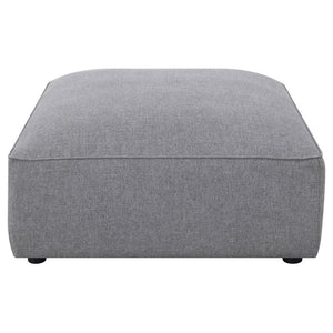  boxy shape is upholstered in a soft grey woven fabric that lends it a hint of texture. With a neutral monochromatic color palette