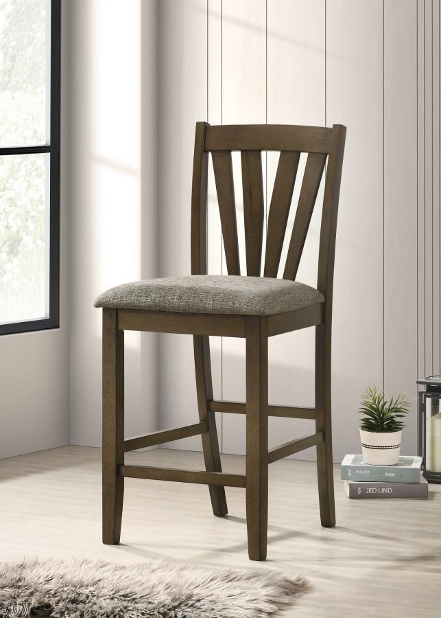 Complete your dining experience with this stylish and comfortable counter height dining chair. Crafted with a solid wood frame, this side chair offers sturdy support while the foam-padded seat cushions provide plush comfort. Upholstered in a grey fabric, 