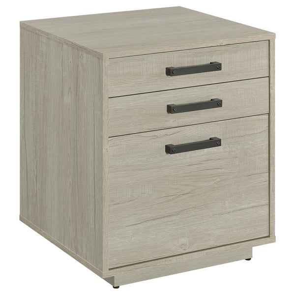 Free up desk space with this contemporary file cabinet, featuring a lovely whitewashed grey finish across its boxy frame and three drawers. Along each drawer is a slim gunmetal finished pull that presents an industrial modern flair to a transitional home 
