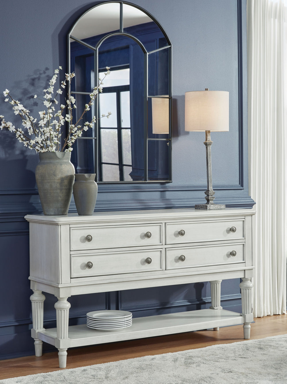 Transform your home into a haven of timeless elegance with this dining server. It pairs a classic antiqued white finish with reeded legs for traditional styling. Four drawers with fully finished interiors offer spacious storage for essentials. The large s