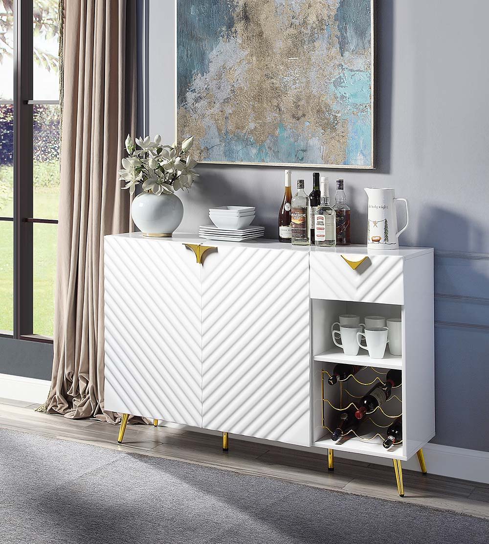 The sleek clean-lined table Gaines dining table offers subtle a hint of glam, the base offers a touch of gold to enhance the textured vertical lined pedestal. The white high gloss finish reflects light and makes any dining space appear larger and grander.