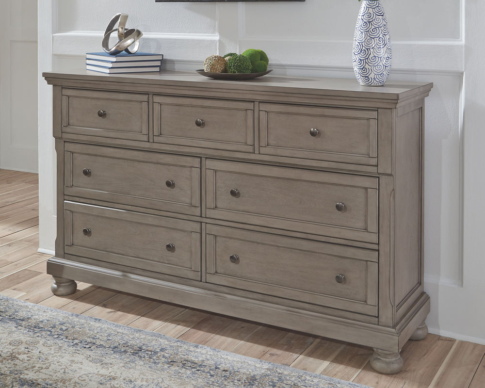 Satisfying your taste for tradition, this dresser sports serene sophistication. Forever classic design detailsâ€”inlaid panels, silvertone patina hardware and bun feetâ€”are so easy to love. A burnished light gray finish elevates the look with modern sens