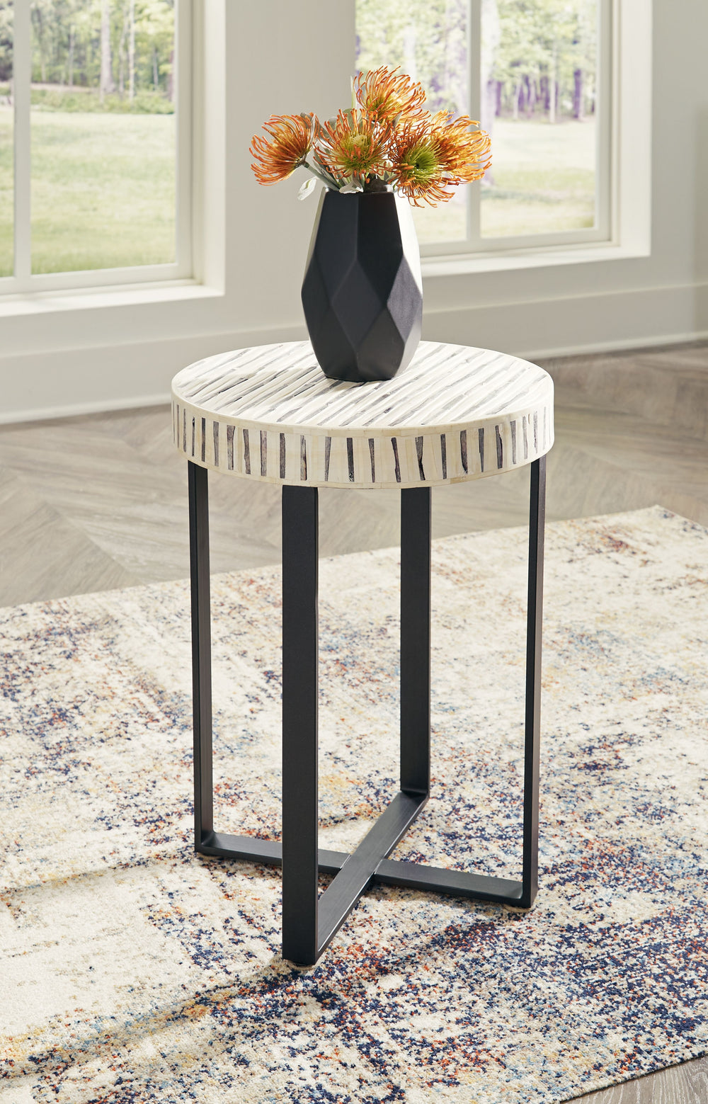 Understatedly cool in its construction, this accent table adds a subtle sense of edginess to your modern decor. Its bone inlay in cream and black creates visual intrigue on the top, balanced out by the sleekly styled black base.<br/><br/><b>Product Featur