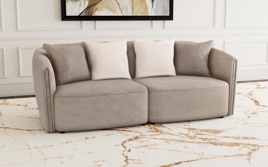 Instill modern appeal with a charming upholstered sofa in soft chenille. Its neutral latte coloration is complemented with tone-on-tone accent pillows, while a slight wavy pattern is the perfect enhancement. A classic shelter silhouette is updated for con