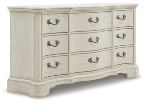 Add a touch of romance to your bedroom with this dresser. Its antiqued white painted finish and serpentine-shaped silhouette details are the picture of easy elegance. Drawers in multiple sizes offer ample storage space, while custom-designed bar pulls add