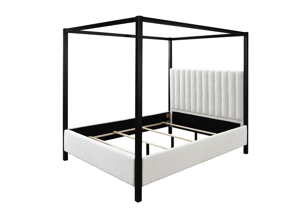 This canopy bed is a modern statement piece, blending the luxurious feel of a traditional four-poster bed with the clean, sleek lines of contemporary design. Its bold, black frame creates a striking silhouette against any bedroom backdrop, while the plush
