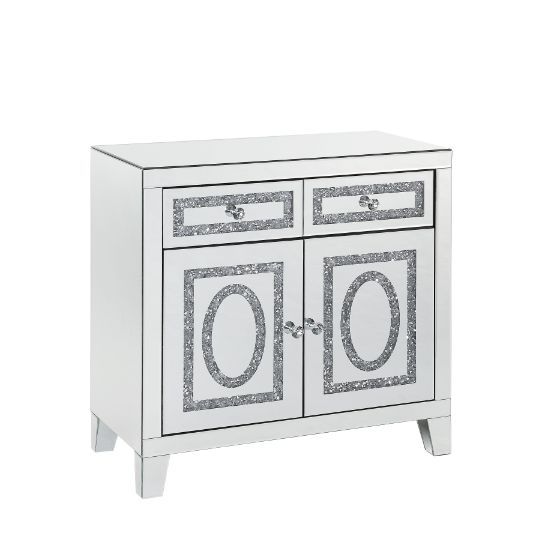 The modern glamour of the Noralie Mirrored Cabinet will brighten your foyer or bedroom. This brilliant cabinet features mirrored finish and faux diamond inlay, adding dimension, contrast, and shine to this functional piece. There are two doors and two dra