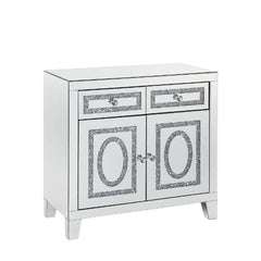 The modern glamour of the Noralie Mirrored Cabinet will brighten your foyer or bedroom. This brilliant cabinet features mirrored finish and faux diamond inlay, adding dimension, contrast, and shine to this functional piece. There are two doors and two dra