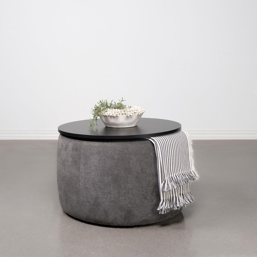 Indulge in the seamless blend of functionality and style with this chic round ottoman. Draped in sumptuously soft grey chenille, it invites relaxation while concealing a spacious storage compartment beneath its sleek black lift-top. Its subtle charm is el