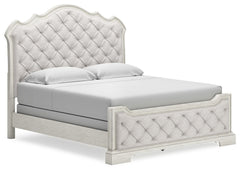 Add a touch of romance to your home with this California king upholstered bed. The antiqued white painted finish and serpentine-shaped silhouette details are the picture of easy elegance. Indulge your love of luxury with decadent button-tufted cushioning 