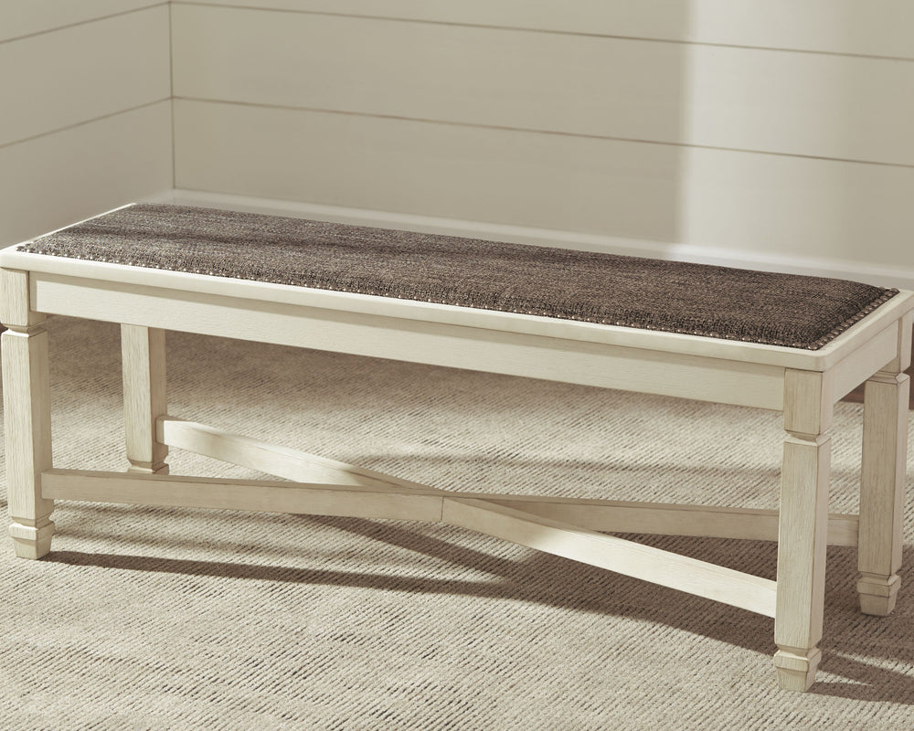 The beauty of this upholstered dining bench is something to savor. Serving up comfort and flair, this generously scaled bench entices with a cushioned seat covered in a heavy woven fabric that complements the antiqued white finish.<br/><br/><b>Product Fea