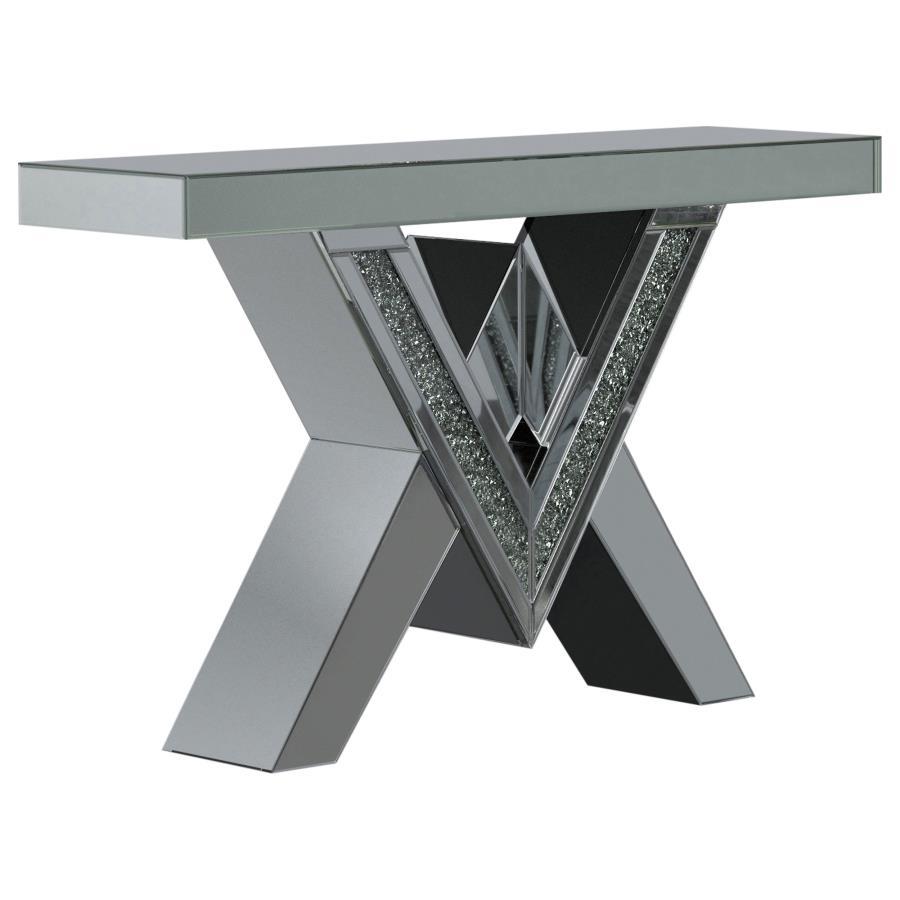 This mirrored console table boasts a striking V-shaped base with angular design elements, featuring inlays of sparkling acrylic crystals. The geometric form is complemented by sleek mirrored surfaces that enhance its modern aesthetic. The design combines 