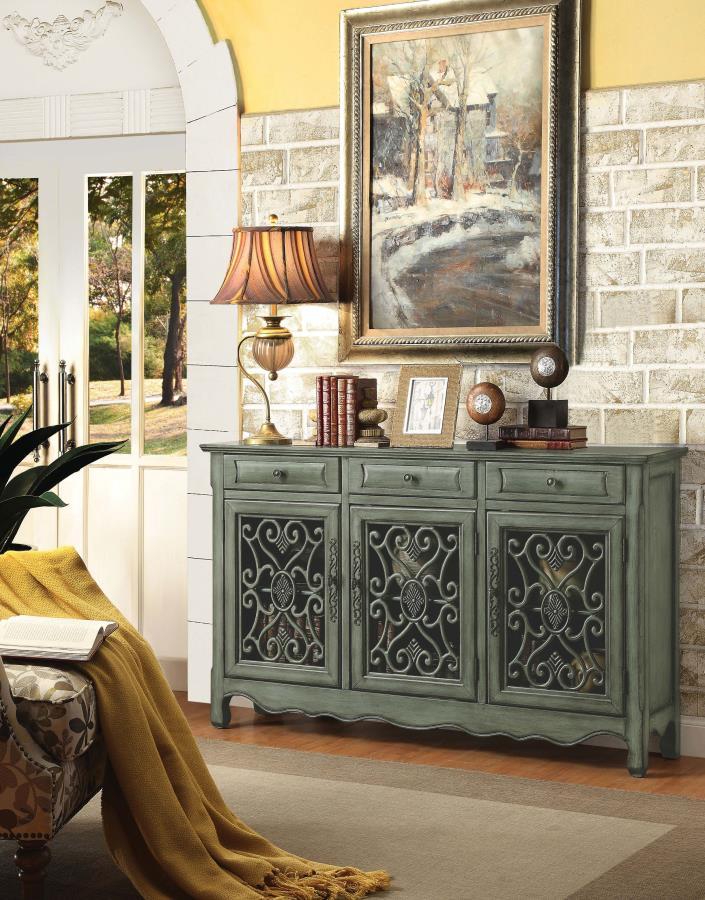 This traditional accent cabinet brings vintage elegance with a romantic twist. Finished in antiqued green, it features intricate bronze hardware, scalloped apron detailing, and sculpted feet. Three doors reveal adjustable interior shelving, while three dr
