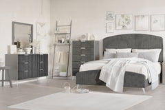 The Kailani 4 Piece Bedroom Set in Gray is a stunning fusion of modern elegance and luxurious comfort. This glamorous set includes an upholstered panel bed, a sleek dresser, a mirror, and a chest, all meticulously crafted to bring sophistication to your b
