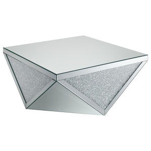 Amplify the style of your living room with this mirrored coffee table. Its bold, diamond-shaped base features triangular mirrored panels with alternating glittery material, adding shimmering sparkle and opulent style. A 40-inch square, reflective surface 