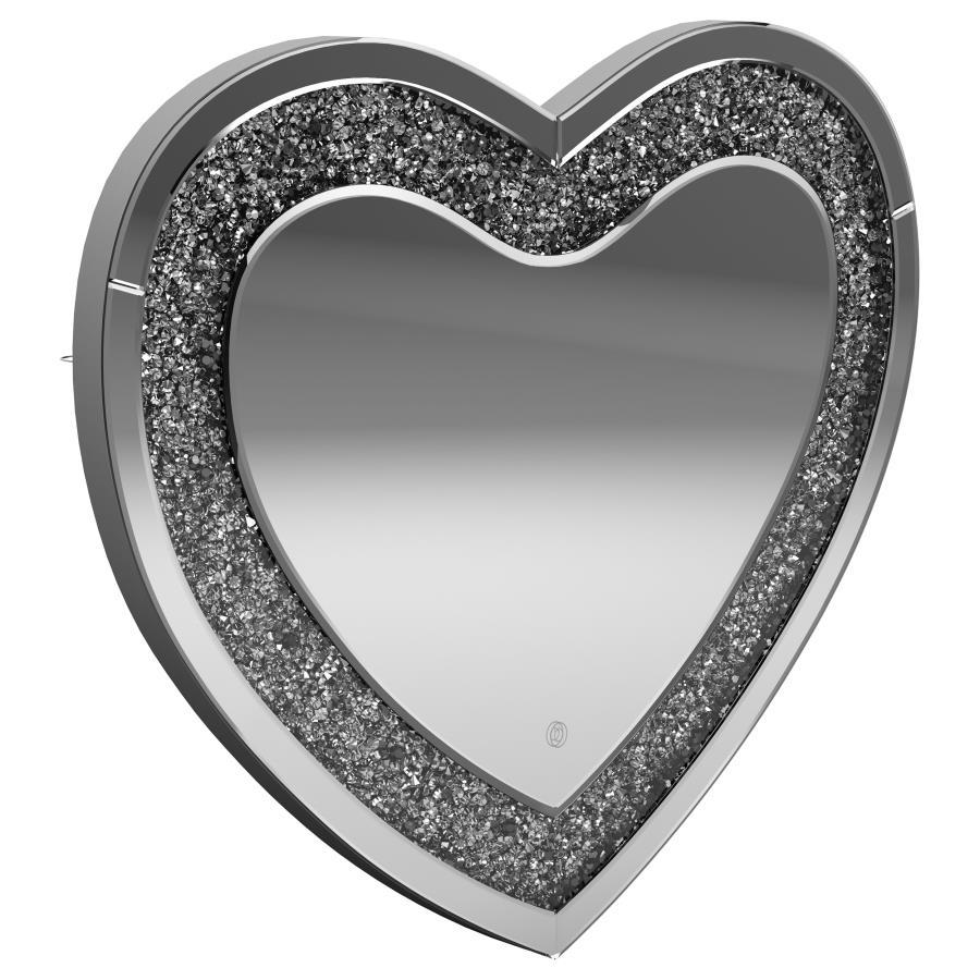 This heart-shaped wall mirror adds sparkle and function to glam-inspired spaces. Framed with mirrored glass and outlined by faceted acrylic crystal inlay, it delivers high-shine appeal. Integrated LED lighting enhances visibility for makeup, grooming, or 