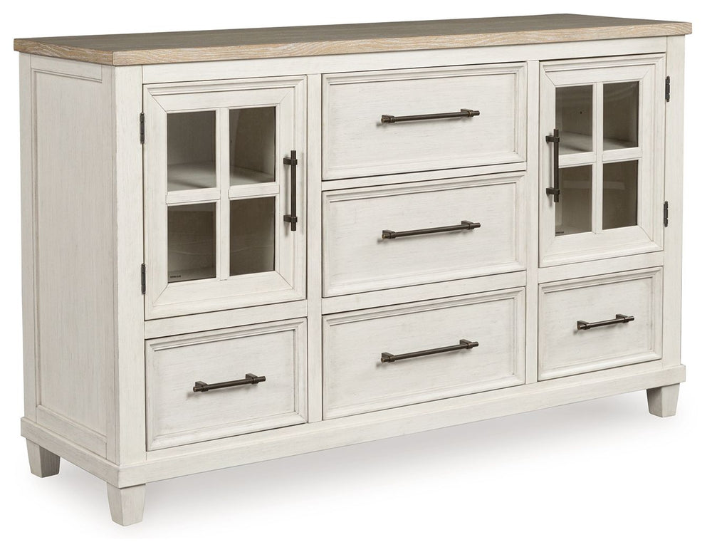 This dresser elevates the art of modern farmhouse design. Its two-tone aesthetic blends antiqued white and light grayish brown for a charming finish. Framed drawer fronts and windowpane cabinets lend a country feel. Conveying a feeling of relaxed comfort,
