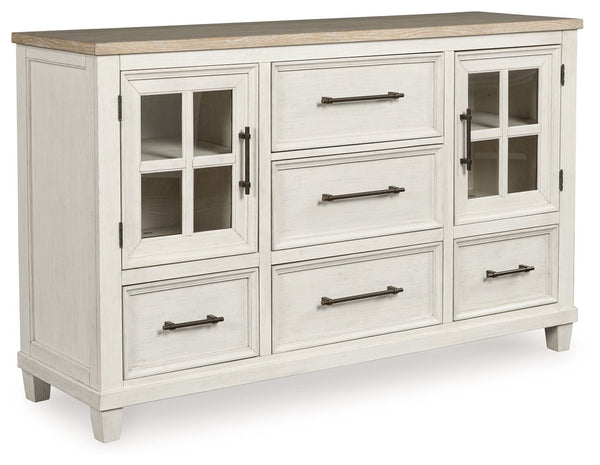 This dresser elevates the art of modern farmhouse design. Its two-tone aesthetic blends antiqued white and light grayish brown for a charming finish. Framed drawer fronts and windowpane cabinets lend a country feel. Conveying a feeling of relaxed comfort,