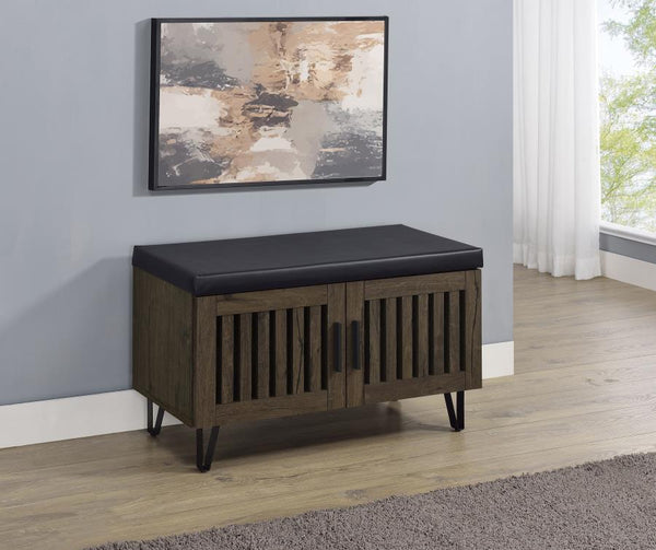  featuring a faux leather upholstered padded top for added versatility as a seating bench. The cabinetâ€™s two doors showcase a vertical slat design