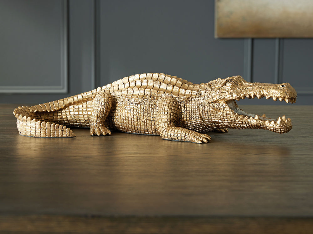 This sculpture brings a glam appeal to wild style. Luxe in an antiqued goldtone finish, the alligator-shaped art piece is a snappy addition to your office or living room decor. Its remarkable attention to detail captures the animal-'s likeness in decidedl