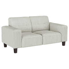 Inject impressive comfort and impeccable style with a modern loveseat in your living room or den. Its tufted back cushions add depth and dimension, perfect for a touch of character in your living area. Plush, soft upholstery in a neutral hue complements p
