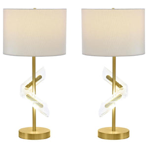 Designed to dazzle, this pair of gold table lamps features a clean drum shade paired with sculptural acrylic accents that wrap around the slender frame. A brilliant LED light glows from within the swirling acrylic, bringing dimension and ambient lighting 