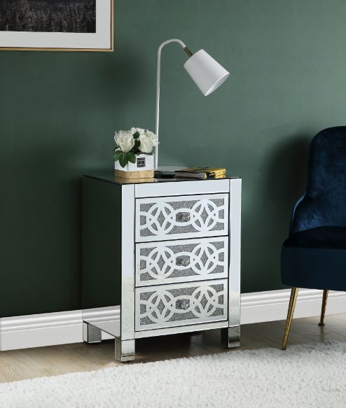 The Noralie Accent Table will give any room a touch of glamour. Mirror and glass materials give it a modern and clear touch while faux diamond inlays add glam style to this piece. Use this unique piece as the perfect accent for any room dÃ©cor. It has thr