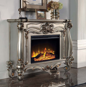 Gather the family around the Versailles fireplace in antique platinum. Traditional details such as scroll legs and carvings make this piece a masterpiece. It comes equipped with fire safety technology that continuously monitors the temperature of the plug