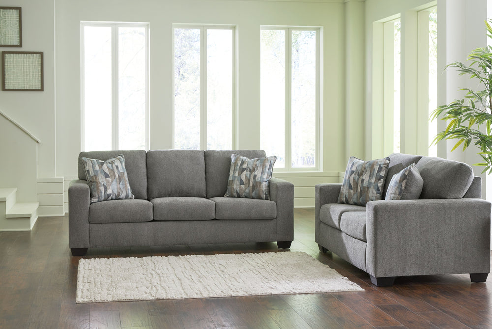 Youâ€™re in for a neat treat with this living room set. Its comfy seats are covered in soft, textural upholstery, and the wide track arms are eager to support your quest for total relaxation. Distressed abstract toss pillows bring a fresh breath of contem
