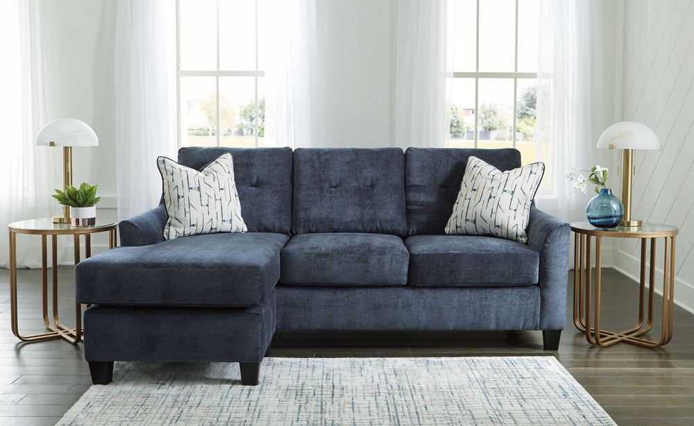 Urban contemporary meets mid century (with a pop of trend-right color) in this sofa chaise. Supremely soft upholstery, teeming with luster and movement, finesses the piece with just the right touch. Gently flared arms and tufted back cushions let you bask
