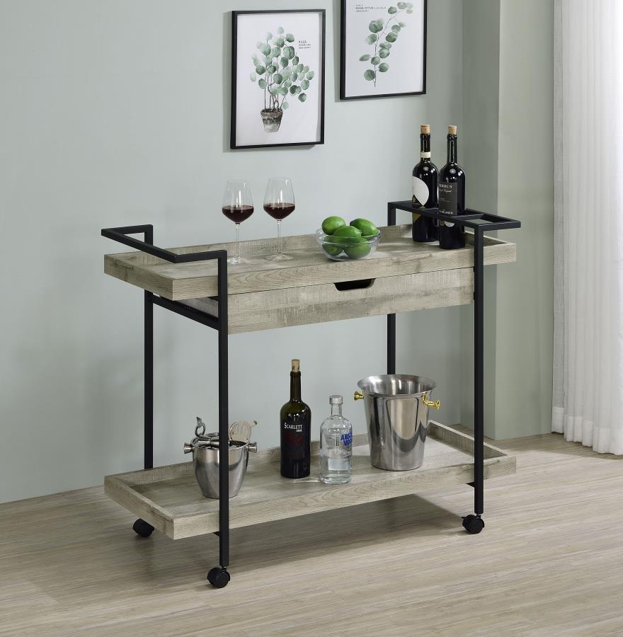 Speakeasy charm meets modern farmhouse in a delightful mobile bar cart. Whether you-'re mixing cocktails or pouring a favorite vintage, the cart offers plenty of space for both storage and prep with a tray-style top and shelf, plus a drawer ideal for acce