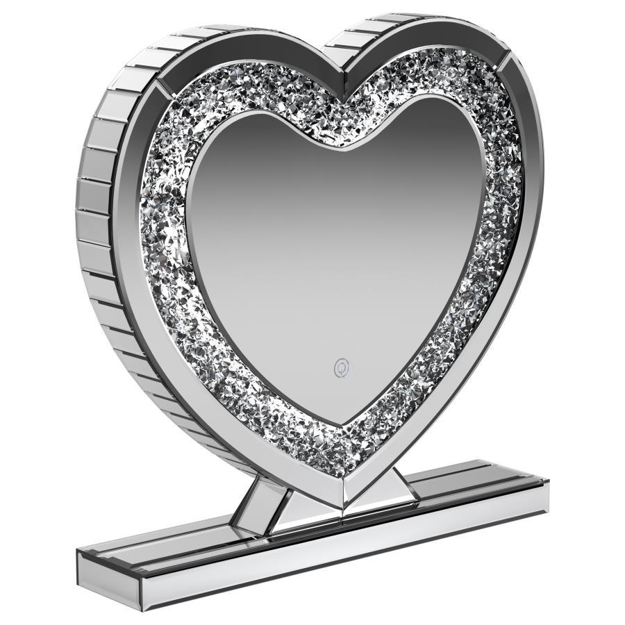 This heart-shaped table mirror blends glam style with practical lighting, perfect for vanities or dressing areas. The mirrored frame features an inset of faceted acrylic crystal inlay that catches light beautifully, while integrated LED illumination adds 